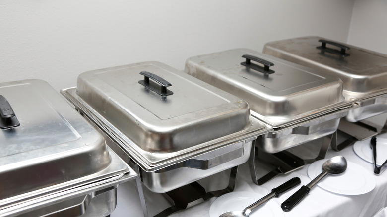 a set of chafer dishes on table with white tablecloth
