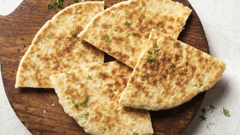 toasted pita on cutting board