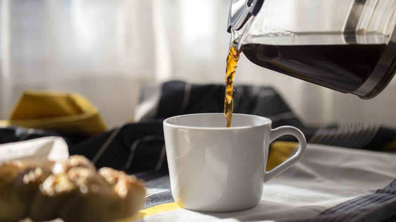 person pouring coffee into a mug