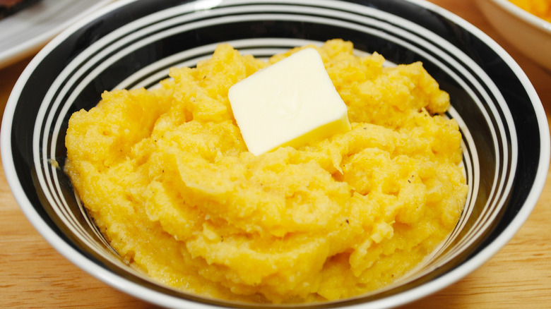 Bowl of mashed turnips with a pat of butter on top