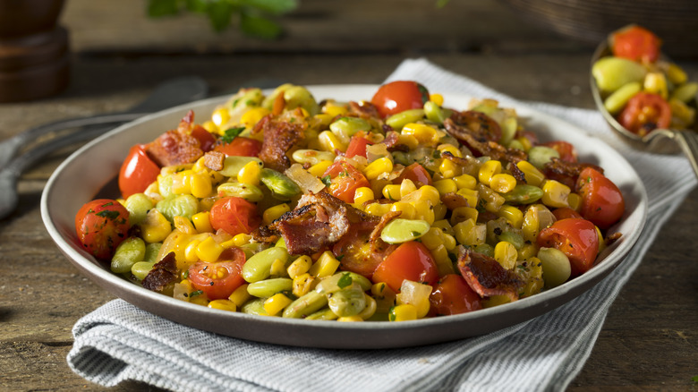 Plate of succotash with tomatoes, bacon, corn, and lima beans