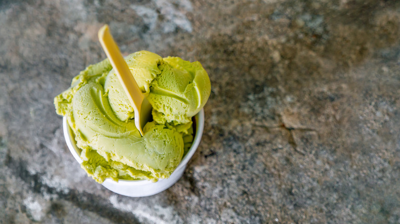 Green ice cream in a bowl on a stone background