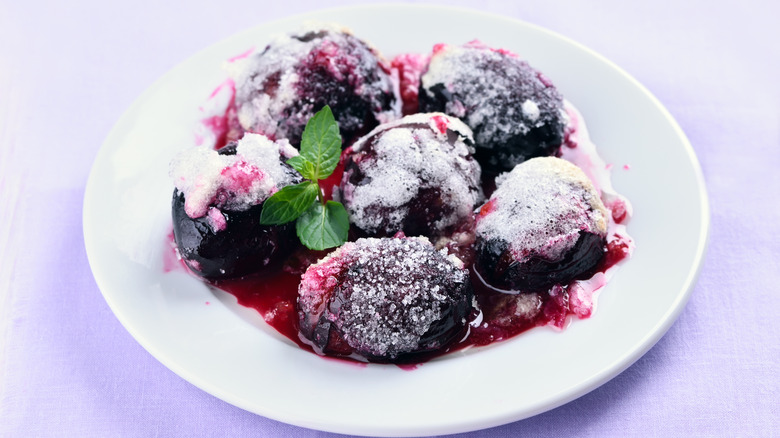 Sugar-covered plums on a white plate