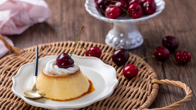 Pudding or flan on a wicker serving tray with cherries