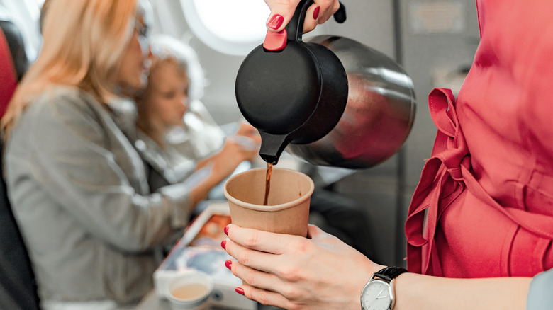Airplane stewardess pouring a coffee on a plane