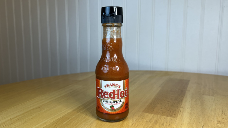 Bottle of Frank's RedHot sauce on wooden table