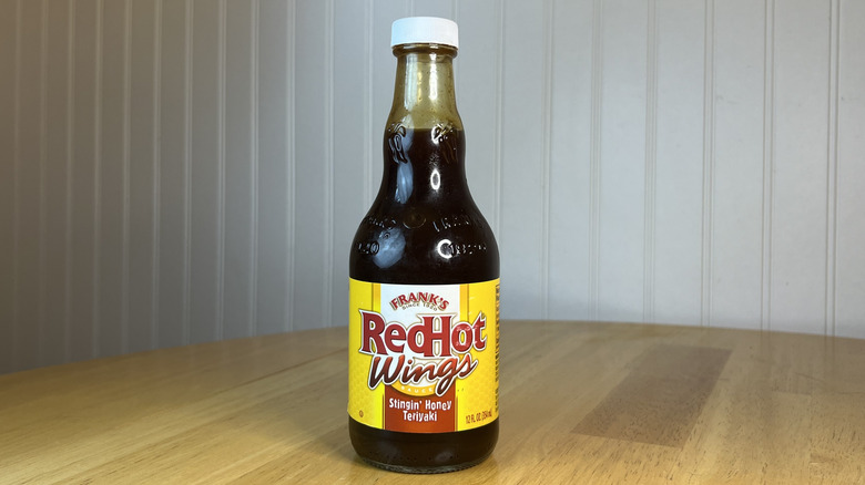 Bottle of Frank's RedHot Wings Stingin' Honey Teriyaki on wooden table