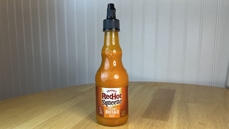 Bottle of Frank's RedHot Squeeze Creamy Buffalo Sauce on wooden table