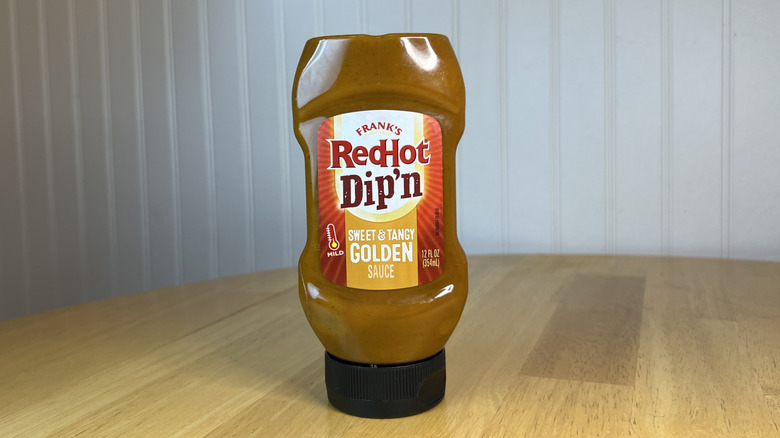 Bottle of Frank's RedHot Dip'n Sweet & Tangy Golden Sauce on wooden table