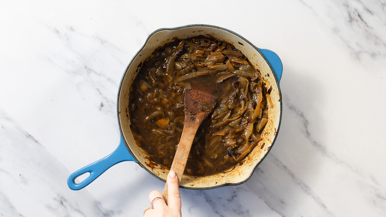 Mixing cooked onions in stock