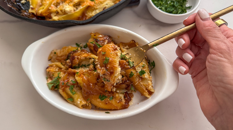 Hand holding forkful of French onion stuffed shells