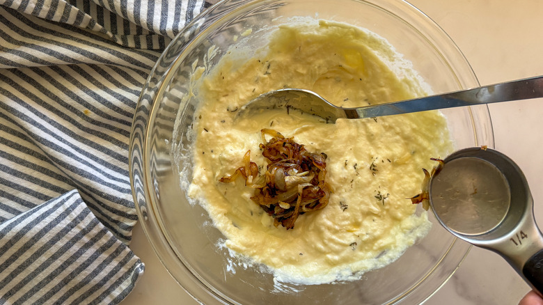 Caramelized onions in bowl of cheese mixture
