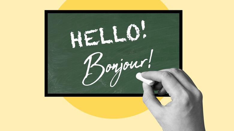 A graphic of a hand writing "Hello! Bonjour!" on a chalkboard