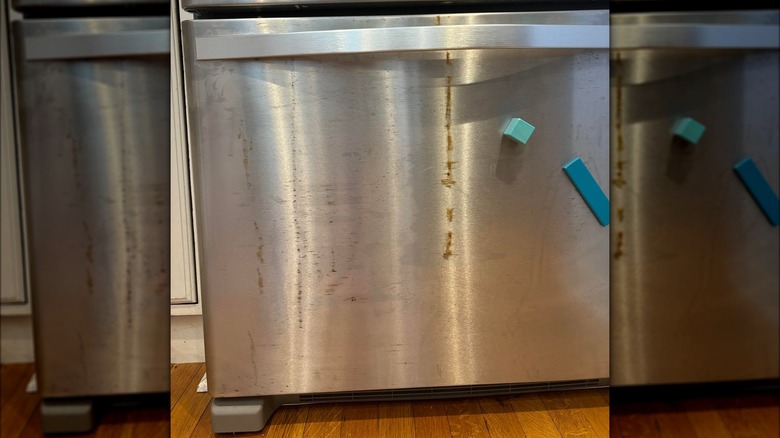 A close-up image of a Whirlpool bottom freezer refrigerator with extensive rusting on the exterior freezer drawer