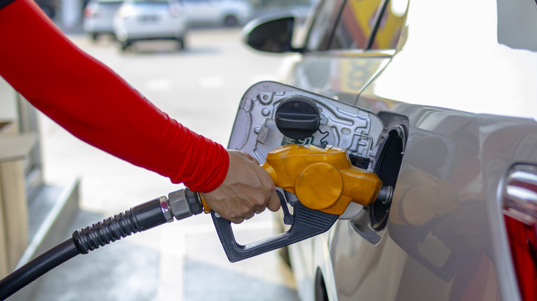 A person filling their car from a gas station fuel pump.