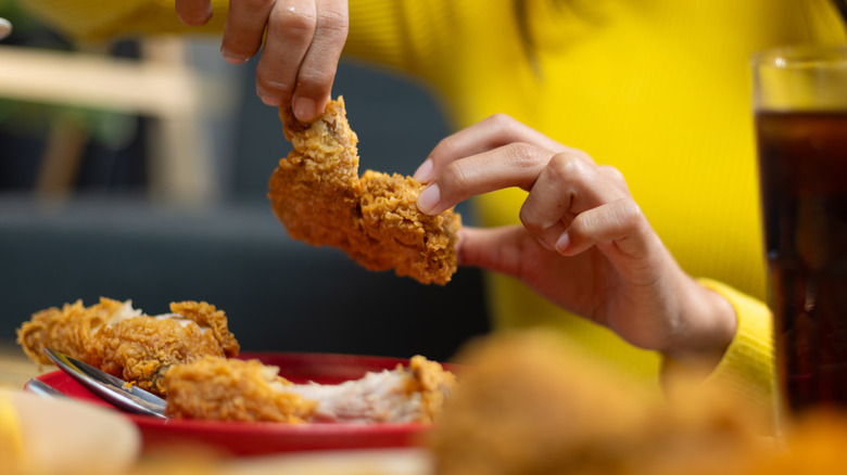 Woman eating fried chicken meal