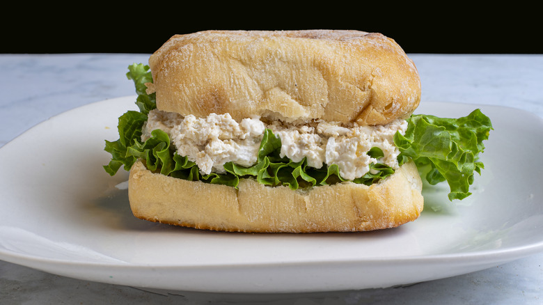 chicken salad sandwich with green leaf lettuce on ciabatta bread
