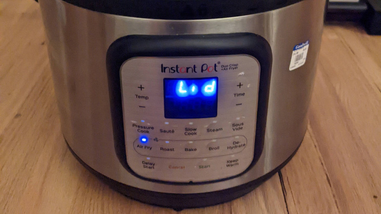 An Instant Pot Duo Crisp + Air Fryer with the error code lid on the screen
