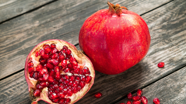 Pomegranate and seeds on wood table