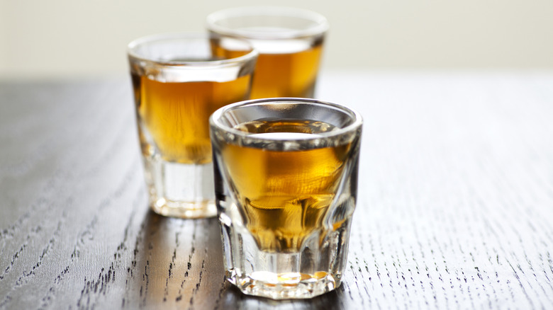 Three shots of whiskey in shot glasses