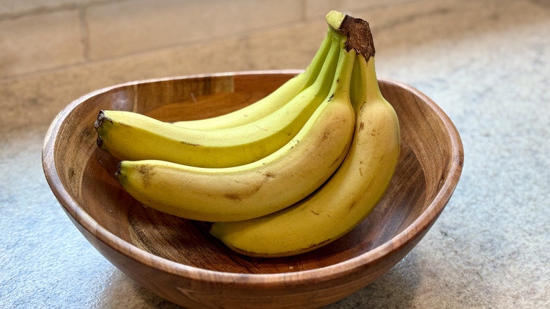 wooden bowl of bananas on a counter