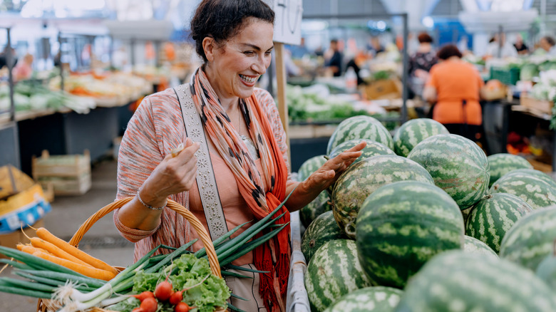 Woman choosing watermelon at market