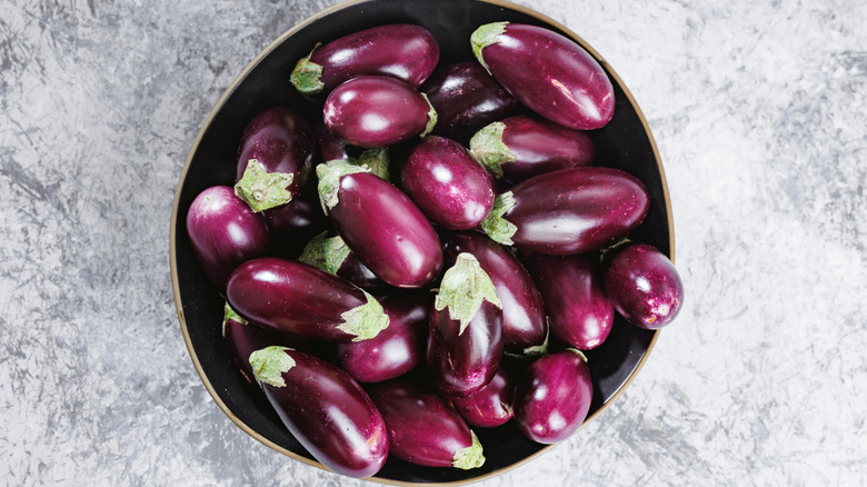 A bowl full of mini purple eggplants