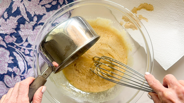 hand pouring chocolate into bowl