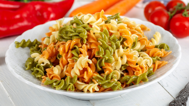 A plate of multi-colored rotini pasta