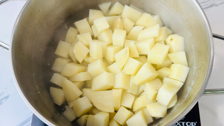 Drained cooked potato cubes in pot