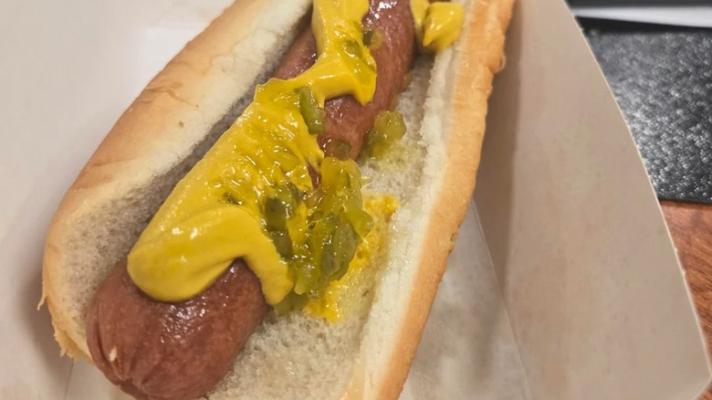 Hot dog on bun with mustard and relish