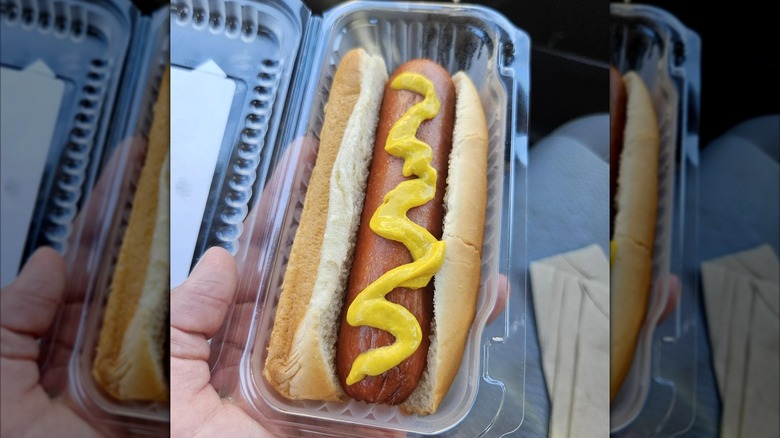Hot dog with mustard in plastic container