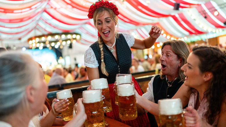 Group of people toasting with beer mugs at Oktoberfest