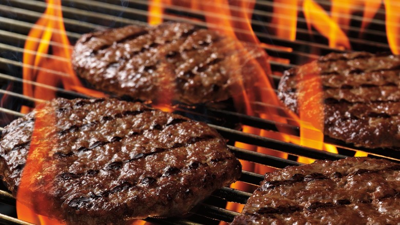 Burger King Whopper patties being flame grilled.