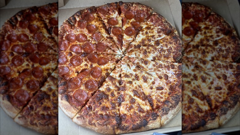 A well-done Costco half-and-half cheese and pepperoni pizza sitting in its cardboard takeout box