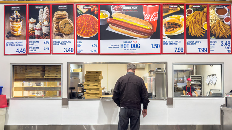 A customer standing at the counter at the Costco food court, waiting to place an order