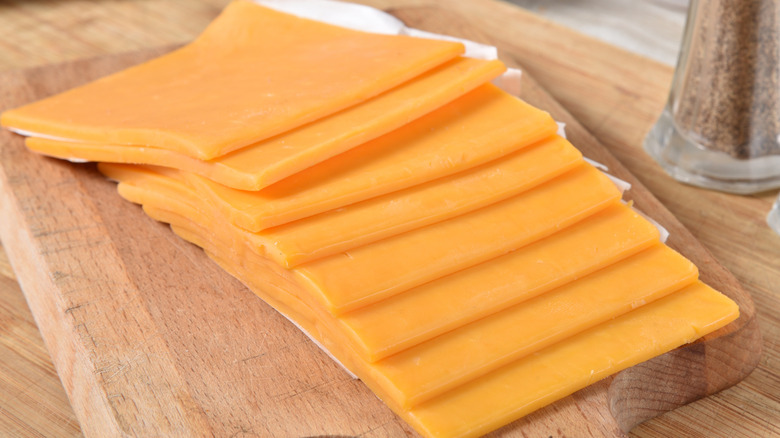 Slices of cheese on cutting board