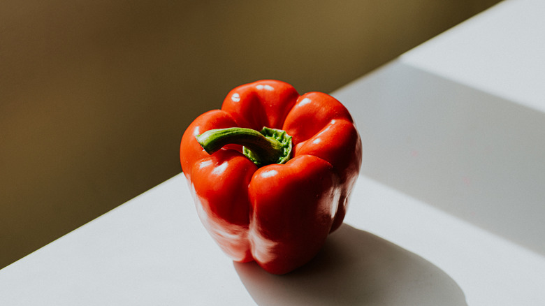 Ripe red bell pepper on a kitchen countertop