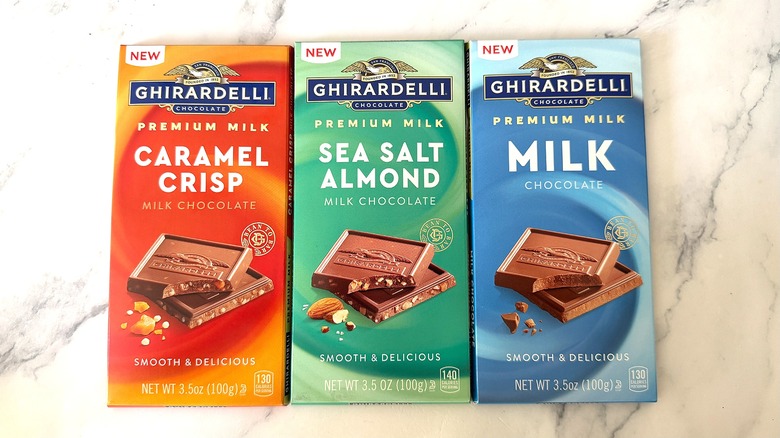 Three Ghirardelli Milk Chocolate Bars on marble surface