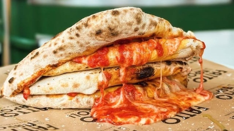 Close-up of pizza libretto with cheese and tomato oozing out