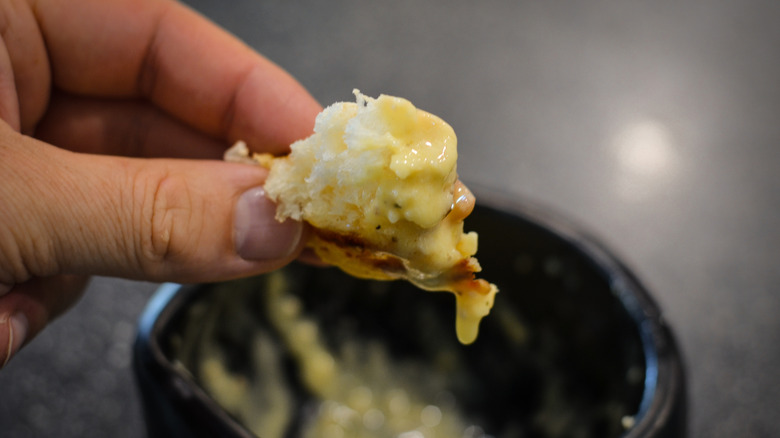 Person using bread to soak up sauce from a bowl