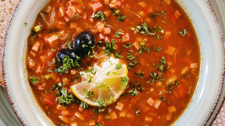 homemade soup with a lemon slice and fresh herbs