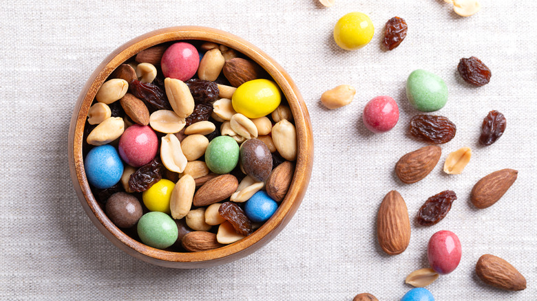A wooden dish is filled with trail mix