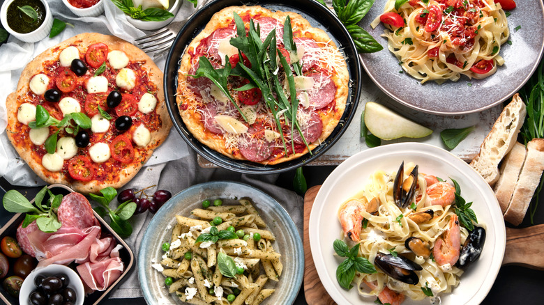 aerial view of an assortment of Italian dishes like pizza, pasta, and sliced meats