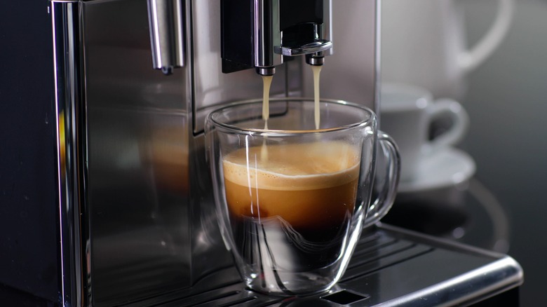 expresso machine filling up a glass cup 