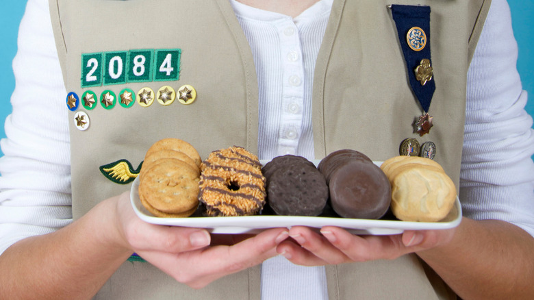 person holding a selection of Girl Scout cookies