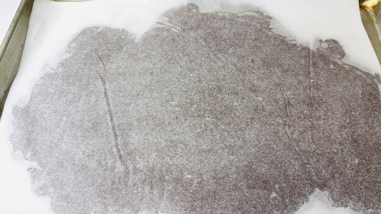 Chilled chocolate cookie dough between parchment paper