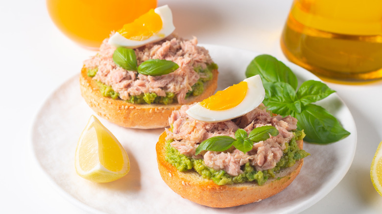 Tuna salad, eggs, and avocado on bagels.