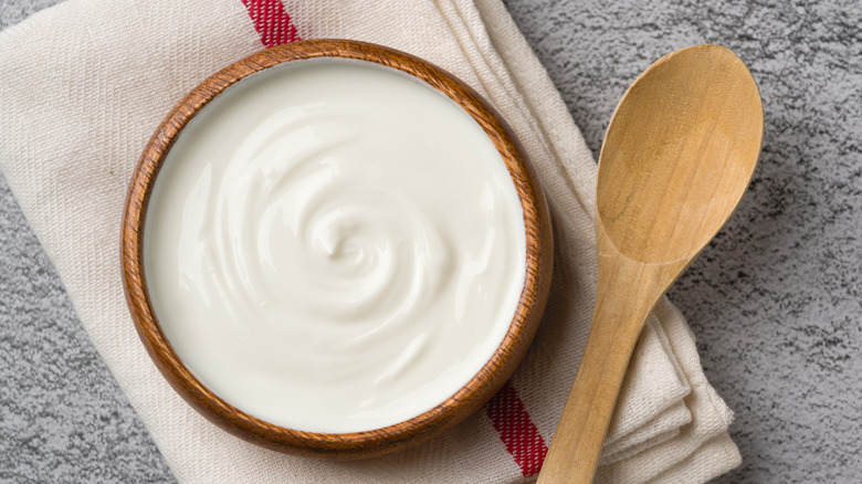 Bowl of Greek yogurt alongside a spoon.