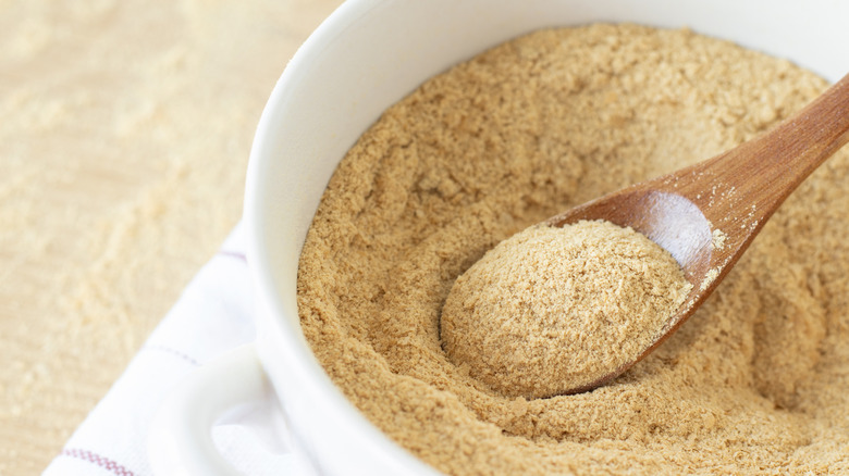 Bowl of nutritional yeast with a spoon.